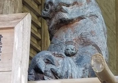 A statue of a cat on the path to Kurama-dera temple